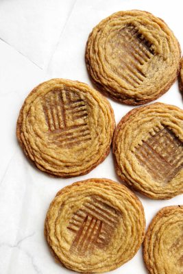 pan-banging peanut butter cookies on white surface