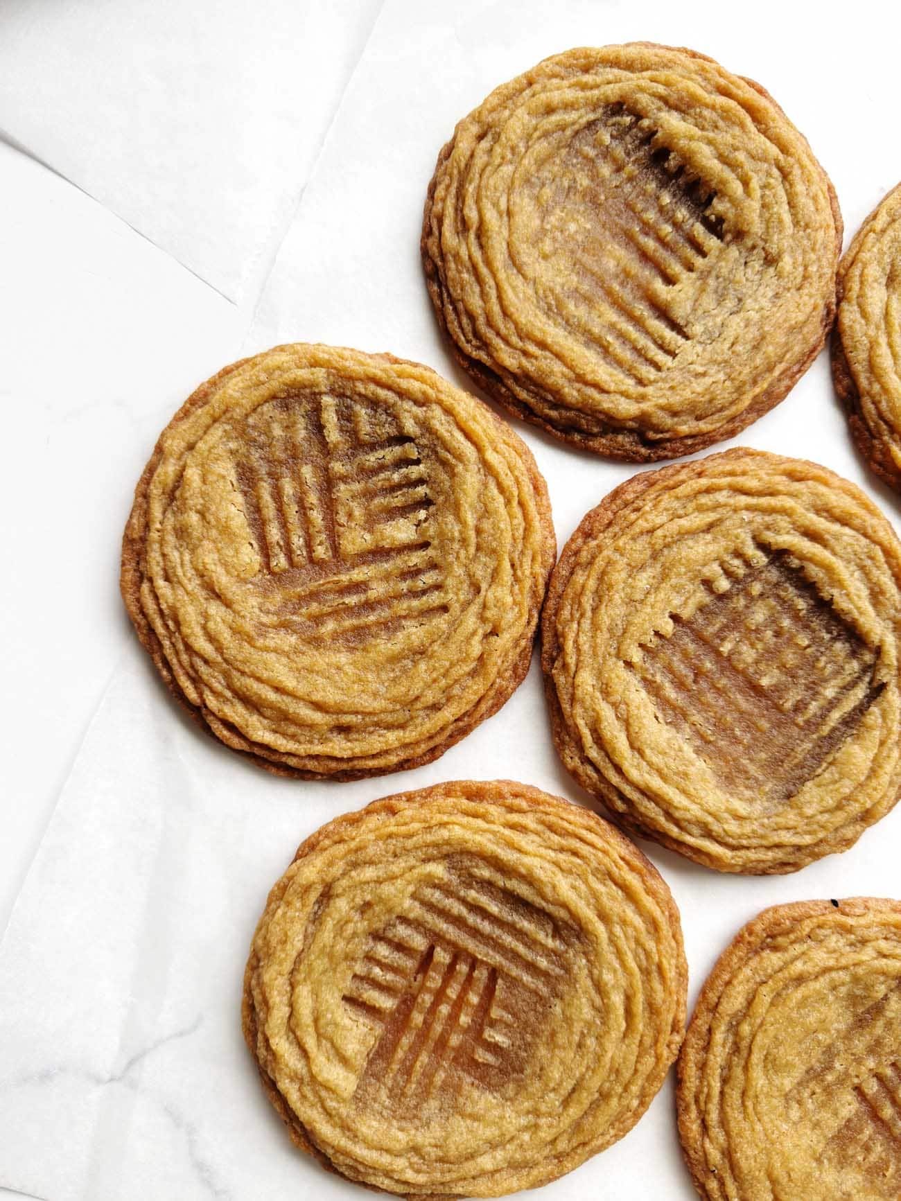 pan-banging peanut butter cookies on white surface