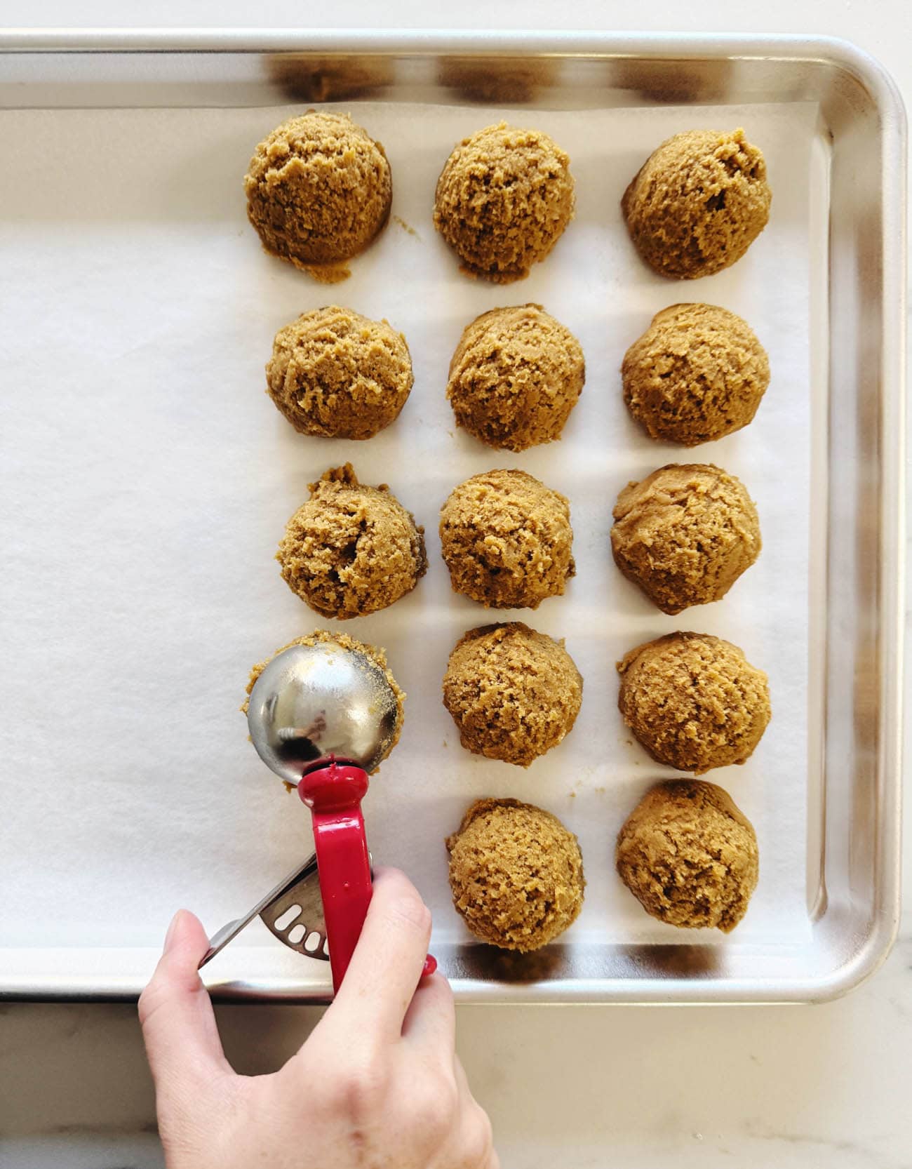 scooping cookie dough onto baking sheet