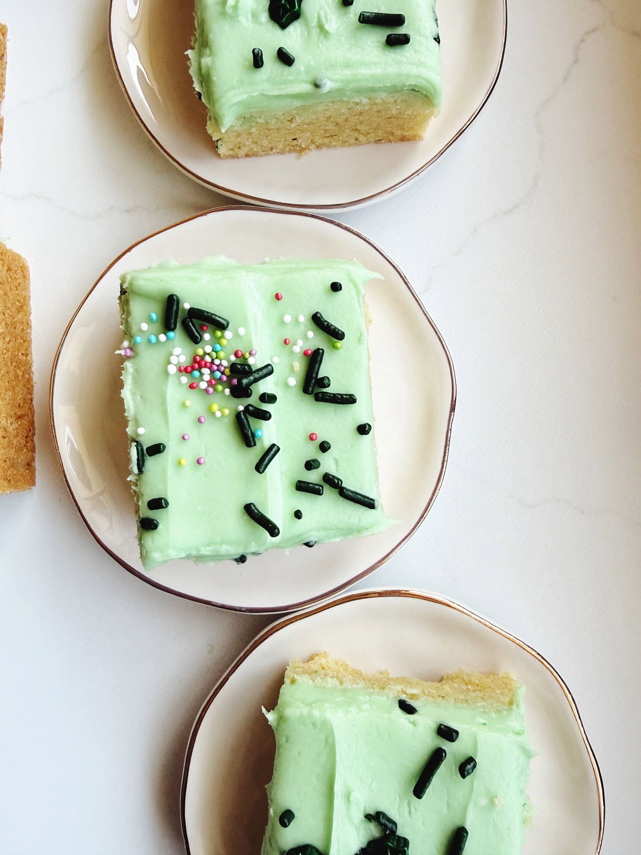 sugar cookie bars on plates, with green frosting